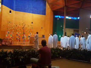 taize kerk, broeders in wit habijt lopen de kerk uit