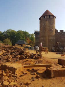 guedelon steenhouwer en kasteel op achtergrond