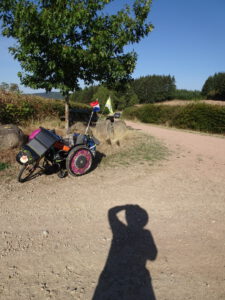 Rolstoelpelgrim schaduw en rolstoel op onverhard pad